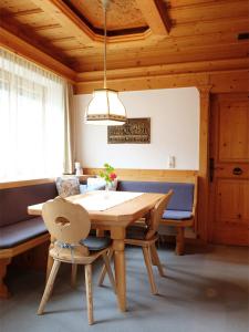 a wooden dining room with a table and a chair at Ferienwohnung Mühlmann in Außervillgraten