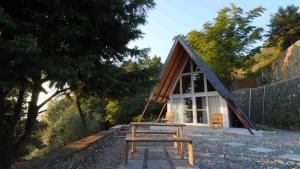 uma pequena cabana com um banco à frente em amã Stays & Trails Godhuli Padam, Naukuchiatal em Nainital