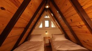 Duas camas num sótão com uma janela em amã Stays & Trails Godhuli Padam, Naukuchiatal em Nainital