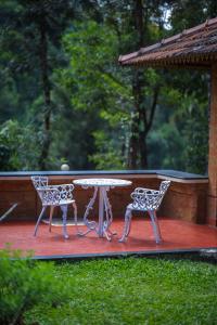 a table and two chairs on a patio at Wild Courtyard Wayanad Resort in Wayanad