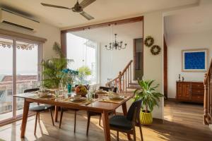 a dining room with a wooden table and chairs at Three Kings in Panaji