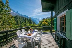 a table and chairs on a deck with a view at Chalet L’eau vive - Happy Rentals in Chamonix-Mont-Blanc
