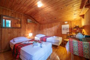 two beds in a room with wooden walls at Chalet L’eau vive - Happy Rentals in Chamonix-Mont-Blanc