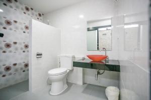 een witte badkamer met een toilet en een wastafel bij บ้านเราอุทัยธานี โฮมสเตย์ in Uthai Thani