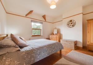 a bedroom with a bed and a window at The Old Farmhouse in Ruabon