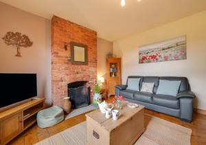a living room with a couch and a fireplace at The Old Farmhouse in Ruabon