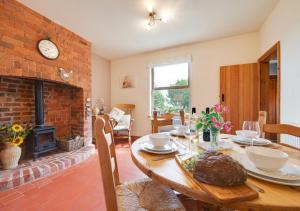 a dining room with a table and a fireplace at The Old Farmhouse in Ruabon