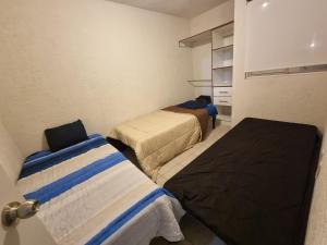 a small room with two beds and a closet at Casa con Alberca Alba in Querétaro