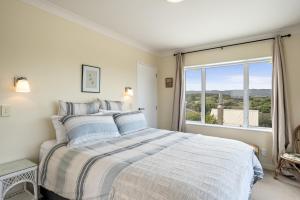 a bedroom with a bed and a large window at Otaki Beach Haven - Otaki Beach Holiday Unit in Otaki