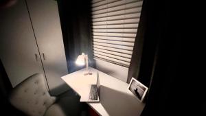 Zimmer mit einem Schreibtisch, einer Lampe und einem Stuhl in der Unterkunft The Ocean House - Budgewoi in Budgewoi + 28 Fotos