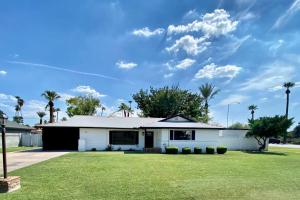 una casa blanca con un patio verde en Newly remodeled beauty in Phoenix en Phoenix