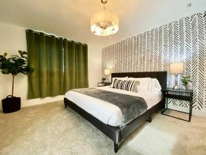 Un dormitorio con una cama grande y una lámpara de araña. en Newly remodeled beauty in Phoenix en Phoenix