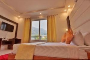 a hotel room with a bed with a large window at BLISS GANGA RISHIKESH , Uttarakhand in Rishīkesh