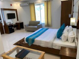 a bedroom with a bed and a couch and a television at BLISS GANGA RISHIKESH , Uttarakhand in Rishīkesh