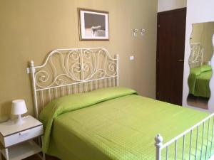 a bedroom with a bed with a green blanket at La Piazza B&B in Vercurago