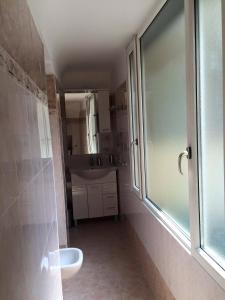 La salle de bains est pourvue d'un lavabo, de toilettes et d'une fenêtre. dans l'établissement La Piazza B&B, à Vercurago