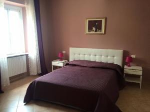 a bedroom with a large bed with a purple blanket at La Piazza B&B in Vercurago