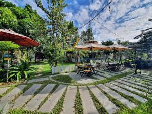 a patio with tables and umbrellas in a park at The Peace House - Siem Reap in Phumĭ Sândăn