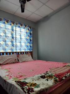 ein Schlafzimmer mit einem Bett mit einer rosa Decke in der Unterkunft KENSONS BUDGETSTAY NON AC FREE WIFI and PARKING in Mangaluru