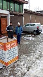 two people standing in a parking lot with a sign at Hotel Jannat in Srinagar