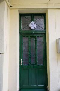 a green door with a glass window on a building at Pest-port apartment room-6 Private apartment in Budapest