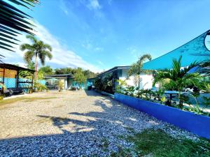 dom z niebieskim płotem i palmami w obiekcie Hidden Palms Inn and Resort w mieście San Juan