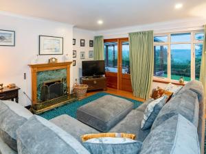 a living room with a couch and a fireplace at Smiddy Cottage in Alyth