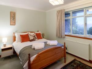 a bedroom with a bed with two pillows on it at Smiddy Cottage in Alyth