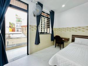 Schlafzimmer mit einem Bett, einem Schreibtisch und einem Fenster in der Unterkunft DREAM HOUSE in Ho-Chi-Minh-Stadt