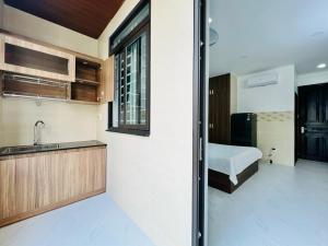 una cocina con fregadero y una cama en una habitación en DREAM HOUSE en Ho Chi Minh