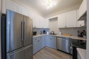 a kitchen with white cabinets and a stainless steel refrigerator at Comfy Nashville 1BR with King Bed and Optional Parking Near Gulch & Midtown Walk to The Parthenon in Nashville