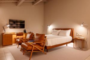a bedroom with a bed and a chair and a desk at DOURWIN - Riverside Suites - Adults Only in Penafiel