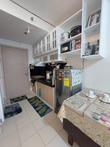 a kitchen with a refrigerator and a table in it at SMDC Cheer Residences in Marilao