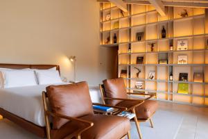a bedroom with two chairs and a bed at DOURWIN Exclusive Suites & Restaurant - Adults Only in Sebolido