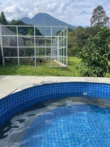 una piscina de azulejos azules con una valla en el fondo en Villa BNA Curug Nangka Taman Sari Bogor, en Cibeunjing