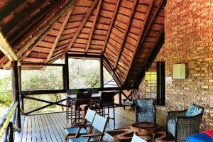 a room with chairs and tables on a roof at Rhinos Rest in Marloth Park