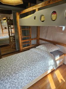 a bedroom with a bunk bed with a wooden headboard at Havre de paix et de verdure proche Walibi et A43 - 4 étoiles in Corbelin
