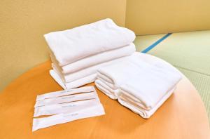 a pile of white towels sitting on a table at COGO TENNOJI in Osaka