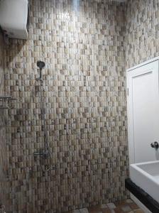 y baño con ducha y lavamanos. en Villa BNA Curug Nangka Taman Sari Bogor, en Cibeunjing