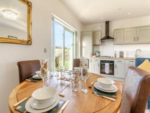 a kitchen with a wooden table with plates and glasses at Rabbit Meadow - Uk46235 in Usk