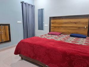 Un dormitorio con una cama grande con una manta roja. en Hotel O Royal Morning Star, en Bhilai