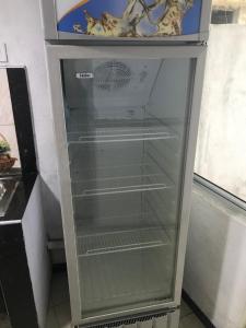 a glass refrigerator with empty shelves in a room at Abi Resort in Galle