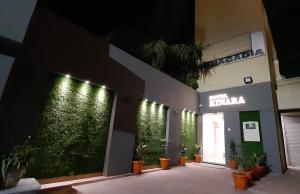 un edificio con plantas y luces en la pared en Hotel Kinara en Ahmedabad