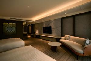 um quarto de hotel com duas camas e um sofá e uma televisão em 綉溪安平 em Anping