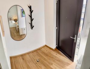 un couloir avec un miroir à côté d'une porte dans l'établissement Stylisches Studio mit privatem Stellplatz wenige Minuten von der Innenstadt & Mosel, à Coblence