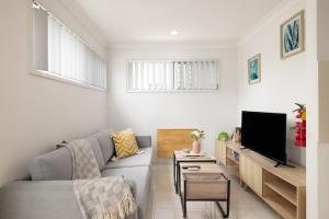 a living room with a couch and a tv at New Listing, Wi-Fi and Laundry in Brisbane
