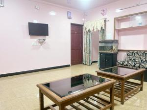 ein Wohnzimmer mit einem Aquarium und einer Couch in der Unterkunft SNR Cottage & Rooms in Udagamandalam
