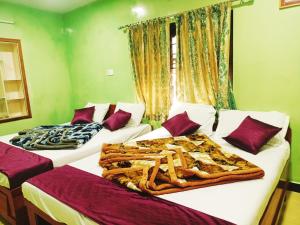 three beds in a room with green walls at SNR Cottage & Rooms in Ooty