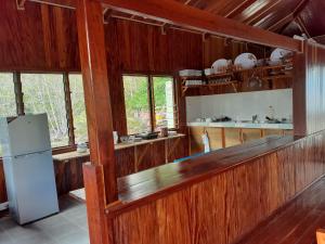 Kolombangara IslandLeleana Resort Kolombangara的厨房设有木墙和冰箱。 更多37张照片
