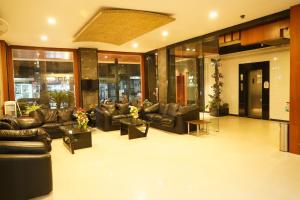 a lobby with couches and tables in a building at Marshall The Grand Hotel in Ahmedabad